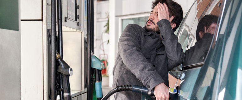 Man Grimaces at the Gas Pump